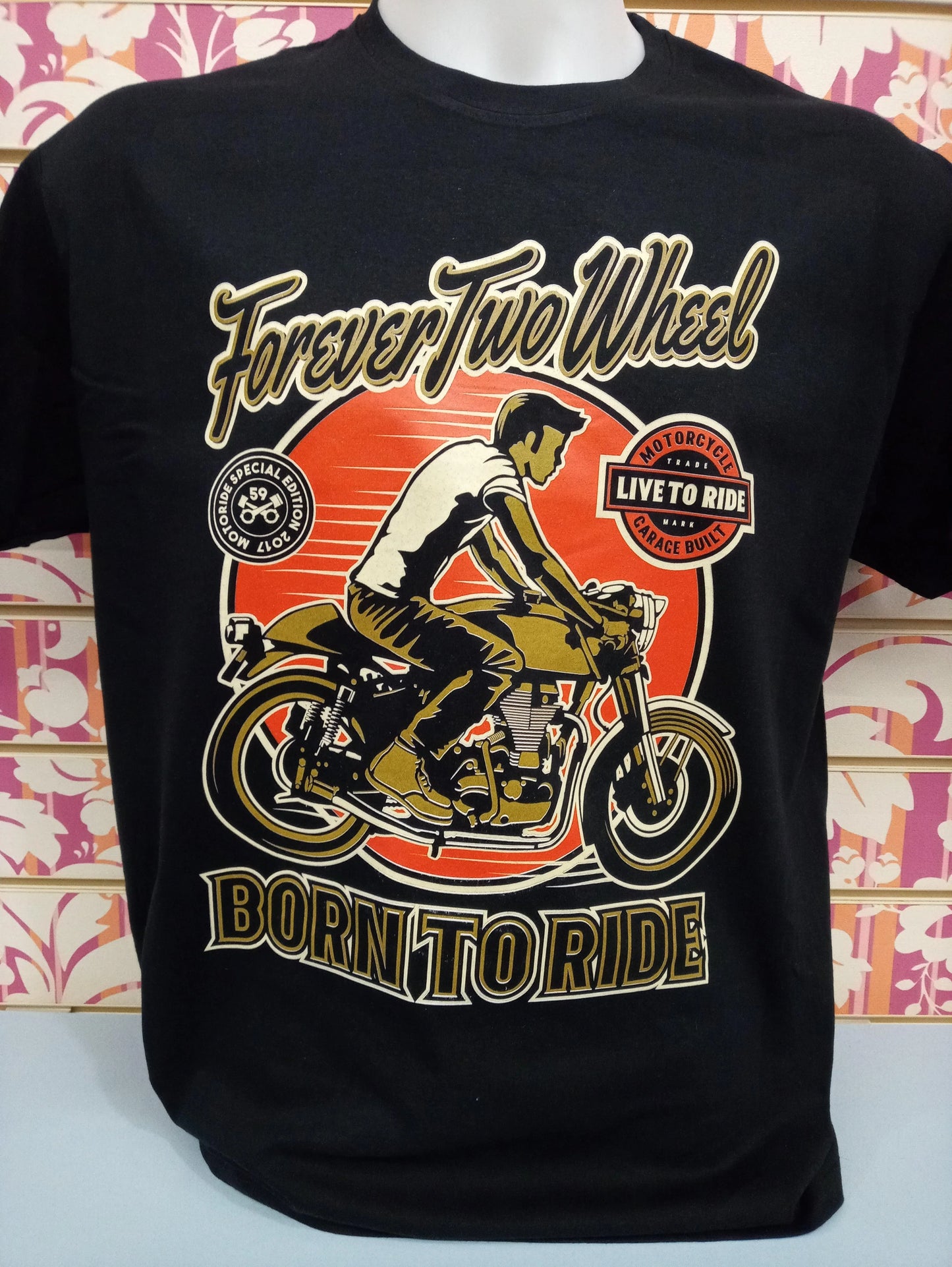 T-shirt streetwear nera con stampa grafica dorata e arancione di motociclista, stile urban.