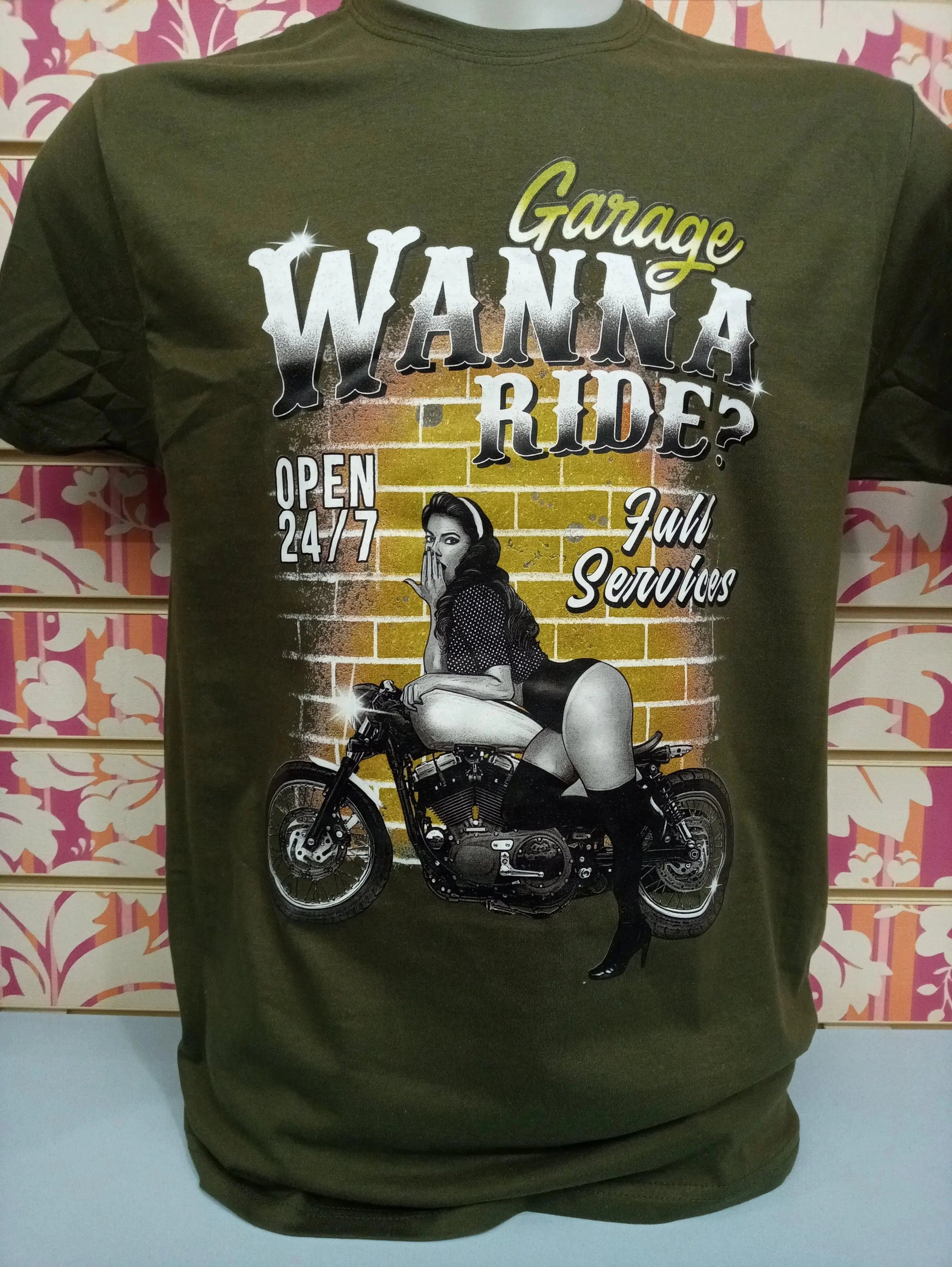 T-shirt streetwear verde militare con stampa urban, donna vintage su moto davanti a muro giallo, stile street style.