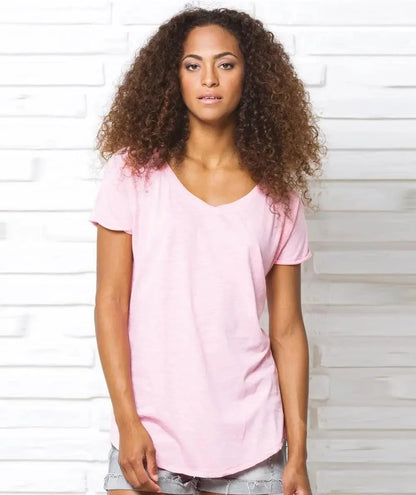 Donna con t-shirt rosa in cotone stile streetwear, pantaloncini denim, ambientazione urban.
