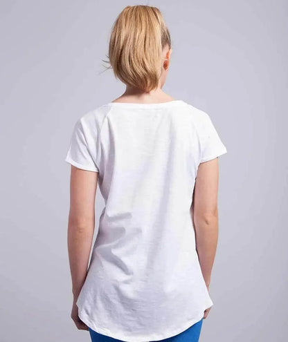 Donna di spalle con t-shirt bianca in cotone, stile streetwear urban, pantaloni blu.