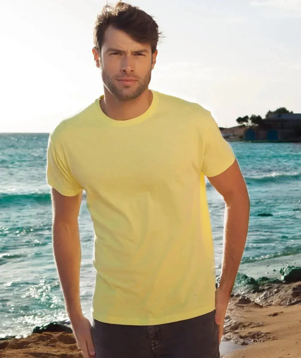 Uomo indossa t-shirt streetwear giallo chiaro in cotone su spiaggia, stile urban casual