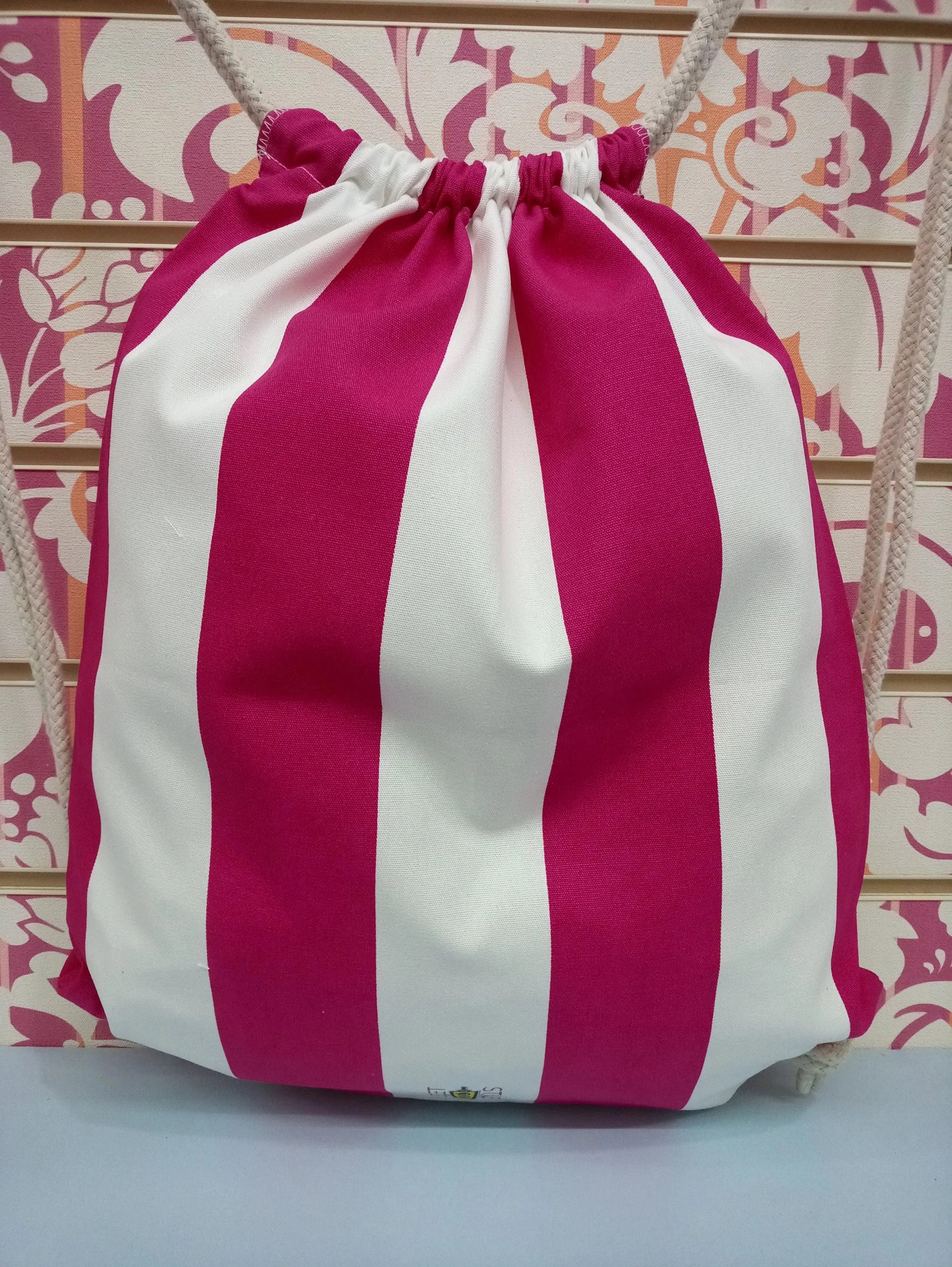 Zaino a sacca streetwear in tessuto con larghe righe fucsia e bianche, stile urban moderno.