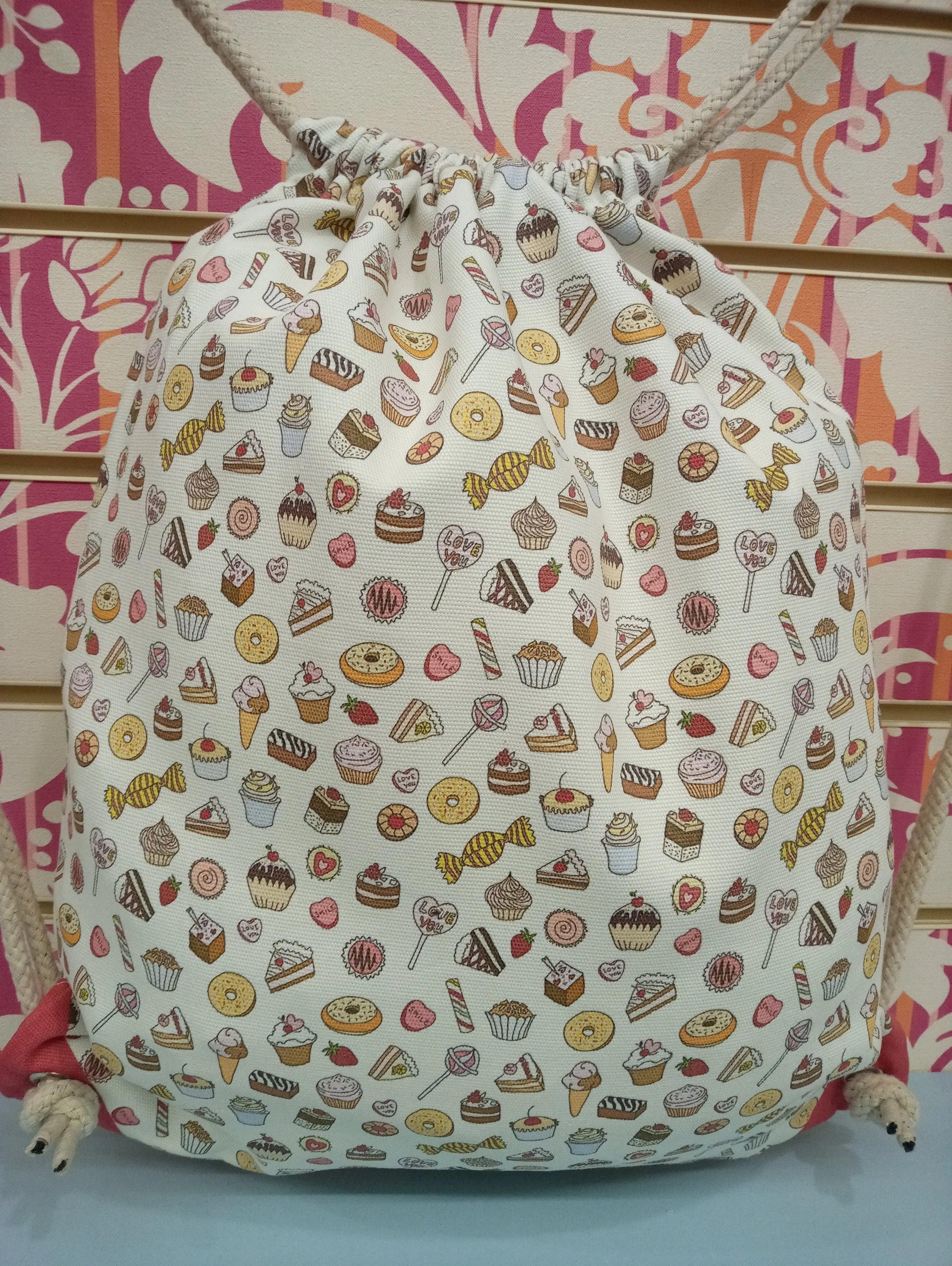 Zaino a sacca streetwear in tessuto bianco, fantasia dolciumi colorati, stile urban casual.