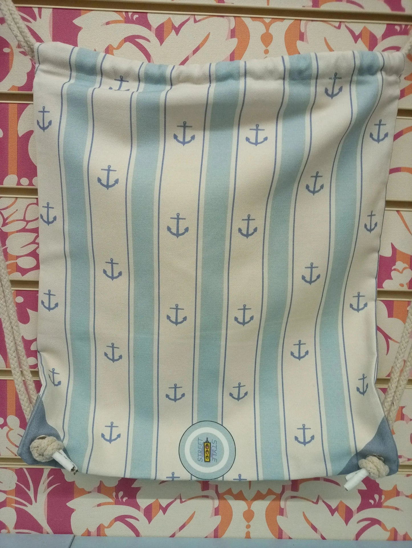 Zaino a sacca stile streetwear, tessuto beige e azzurro con ancore blu, chiusura corda, design urban