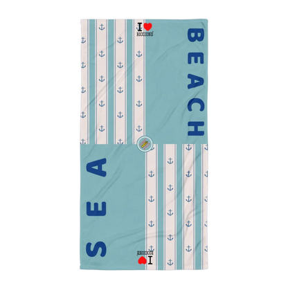 Telo mare streetwear azzurro con strisce bianche, ancore blu e scritte SEA BEACH in stile urban.
