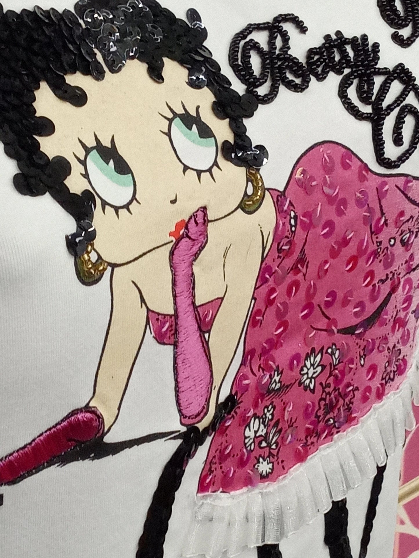 T-shirt bianca streetwear con stampa Betty Boop, dettagli rosa, paillettes e ricami, stile urban.