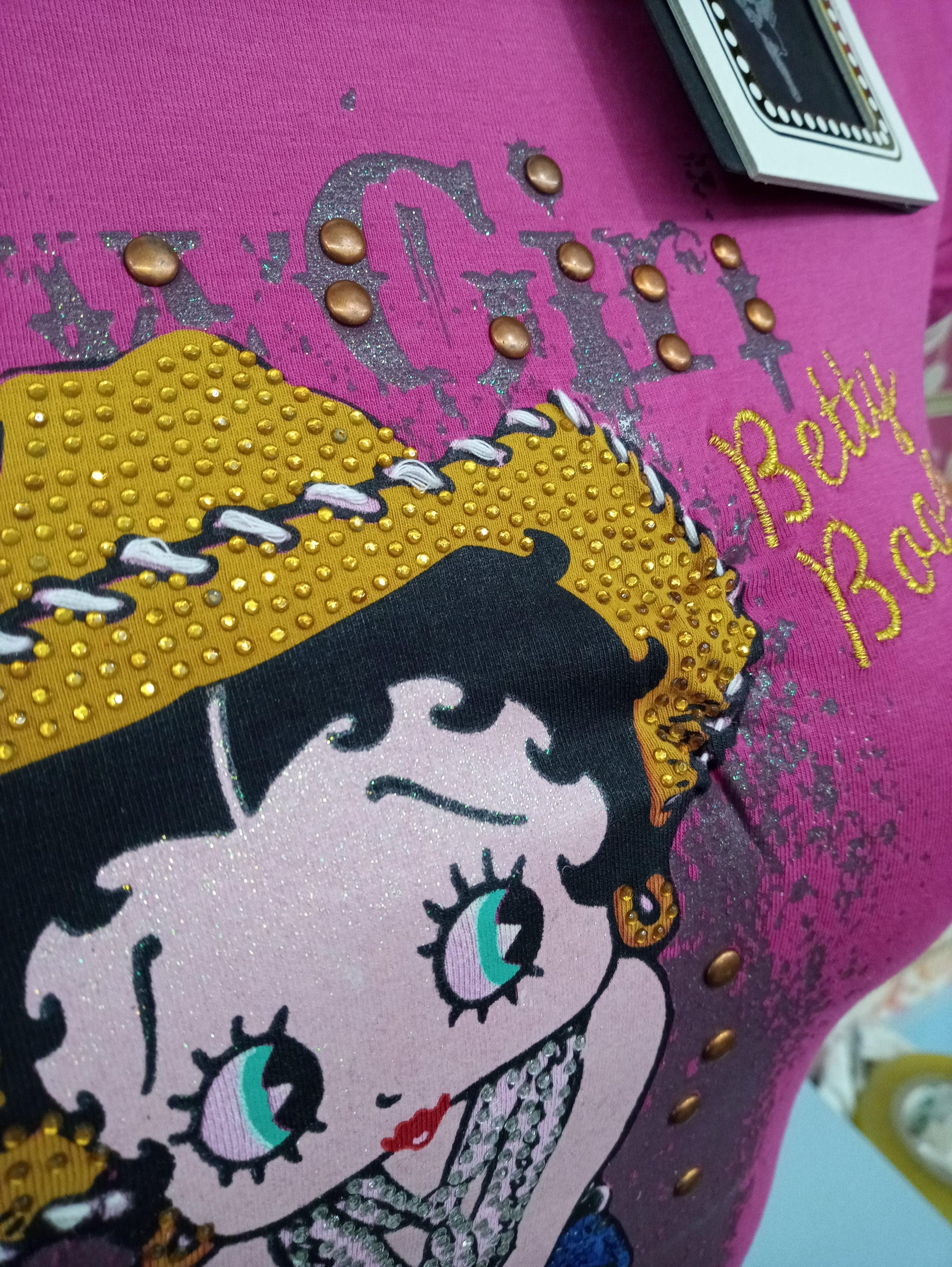 T-shirt donna streetwear fucsia con stampa Betty Boop, dettagli glitter e borchie, stile urban.